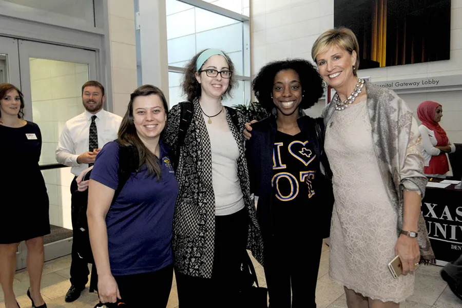 Chancellor Feyten poses with three students