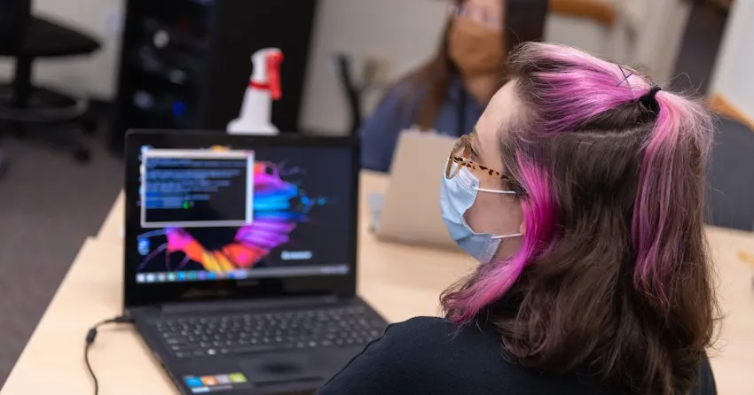 Students in masks working in a computer lab  