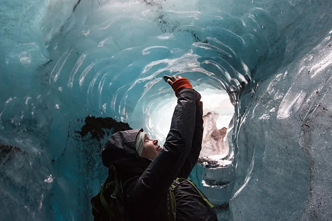A Fulbright student studies the interior of an iceburg in Iceland