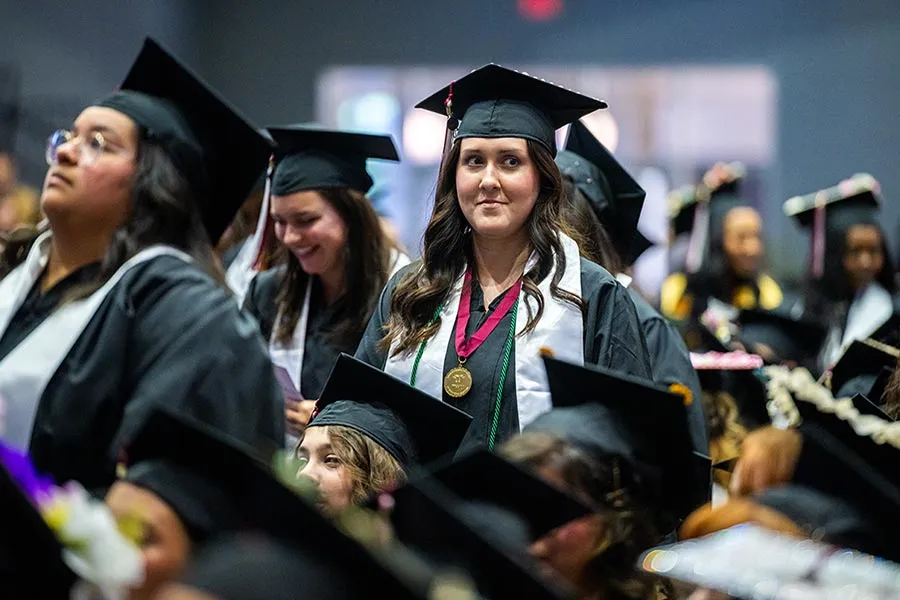A TWU student at Commencement wearing the scholar medallion with her cap and gown