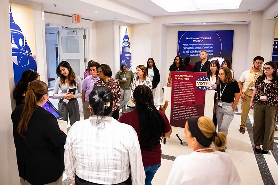 A group of young women gather in the Sue Bancroft Leadership Hall to view the Texas Women in Politics exhibit
