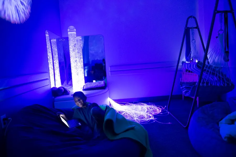 A young boy relaxes in the sensory room on TWU's Dallas campus.