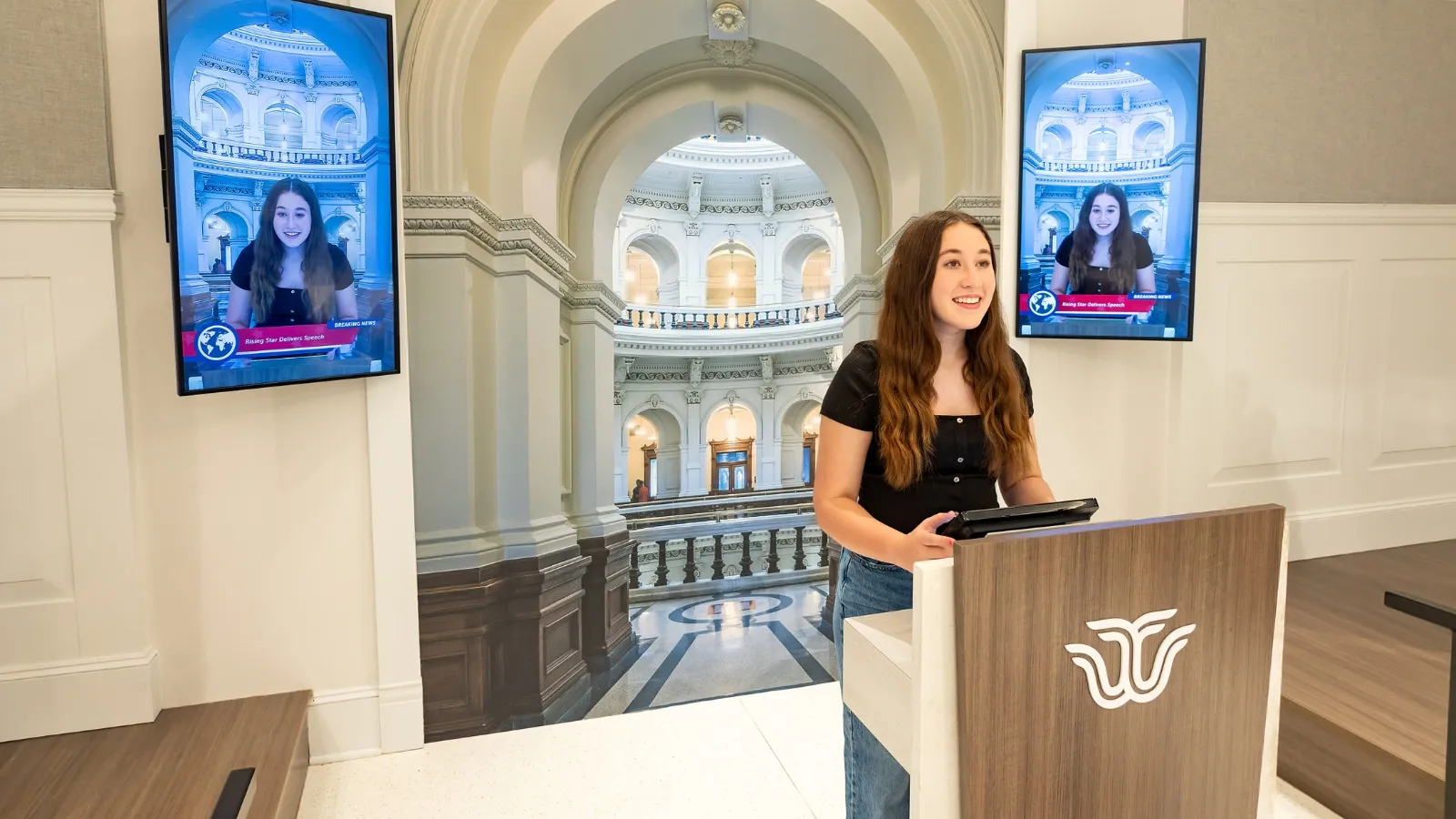 Student delivers a Texas women leader's speech at the podium in the gallery.