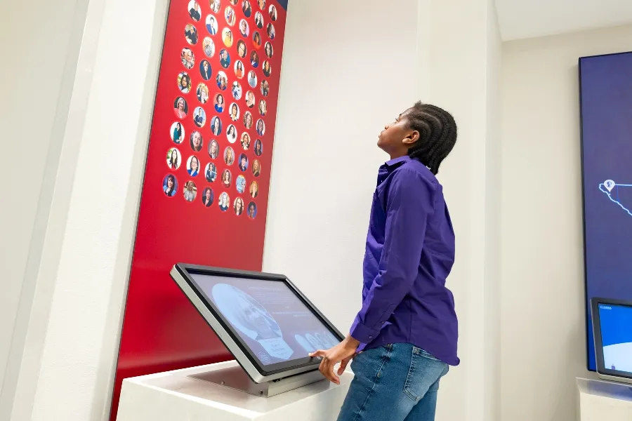 A student looks at a photo display of the women who ran for office in Texas in 2018. 