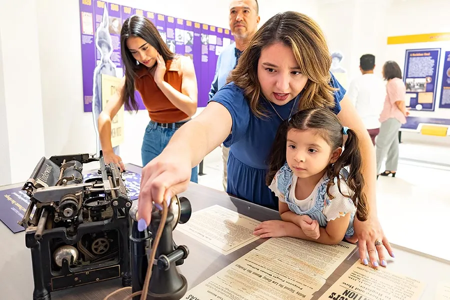 A family looks at the communication devices from the suffrage period of history.