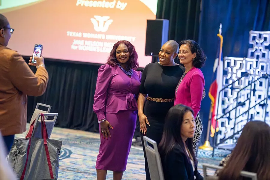 An attendee of the 2023 Leading the Lone Star State summit takes a photo of speakers Dawn Freeman, Symone Sanders-Townsend, and Stella Chavez