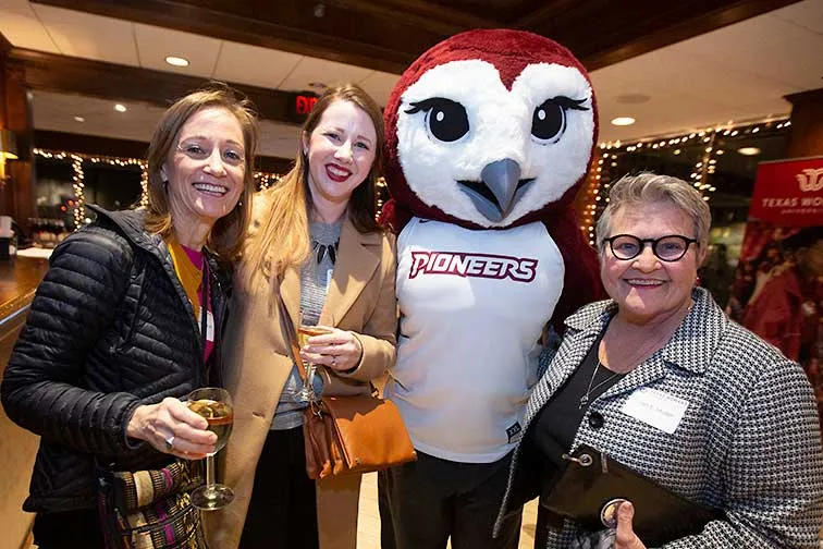 TWU faculty and staff pose with mascot Oakley.