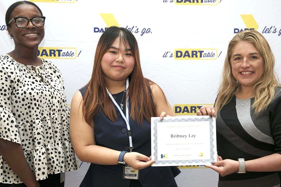 TWU student Brittney Lay holds a certificate in between two staff members