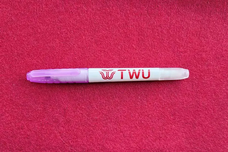 A purple highlighter with a TWU logo on the side.