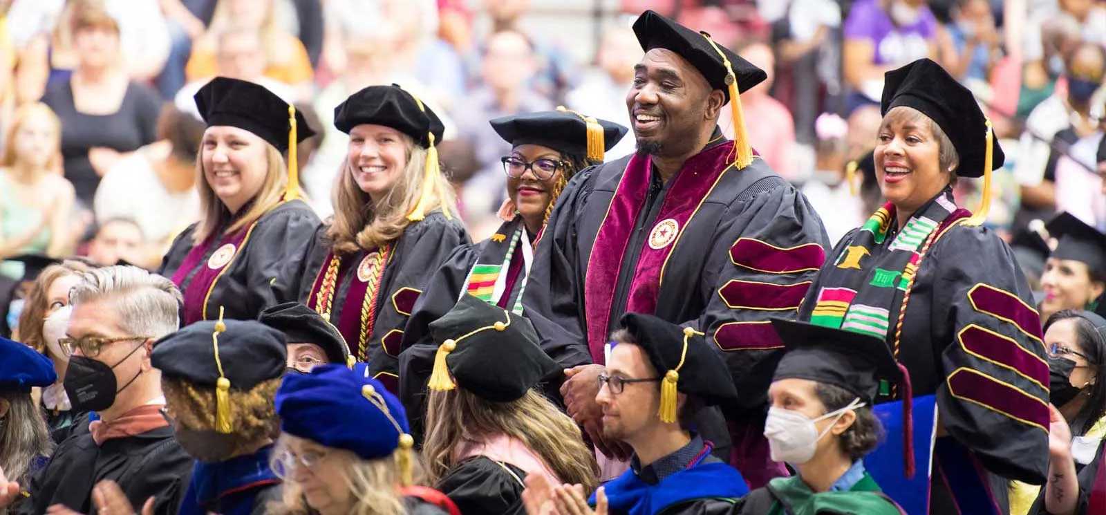A group of McNair Scholars at Commencement wearing their regalia