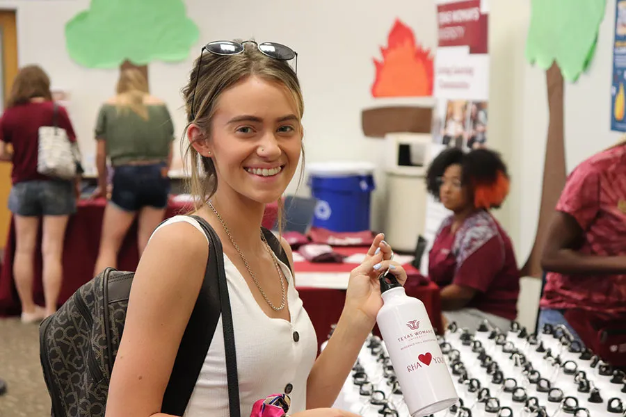A student receives her Residence Hall Association water bottle on move-in day 2019.