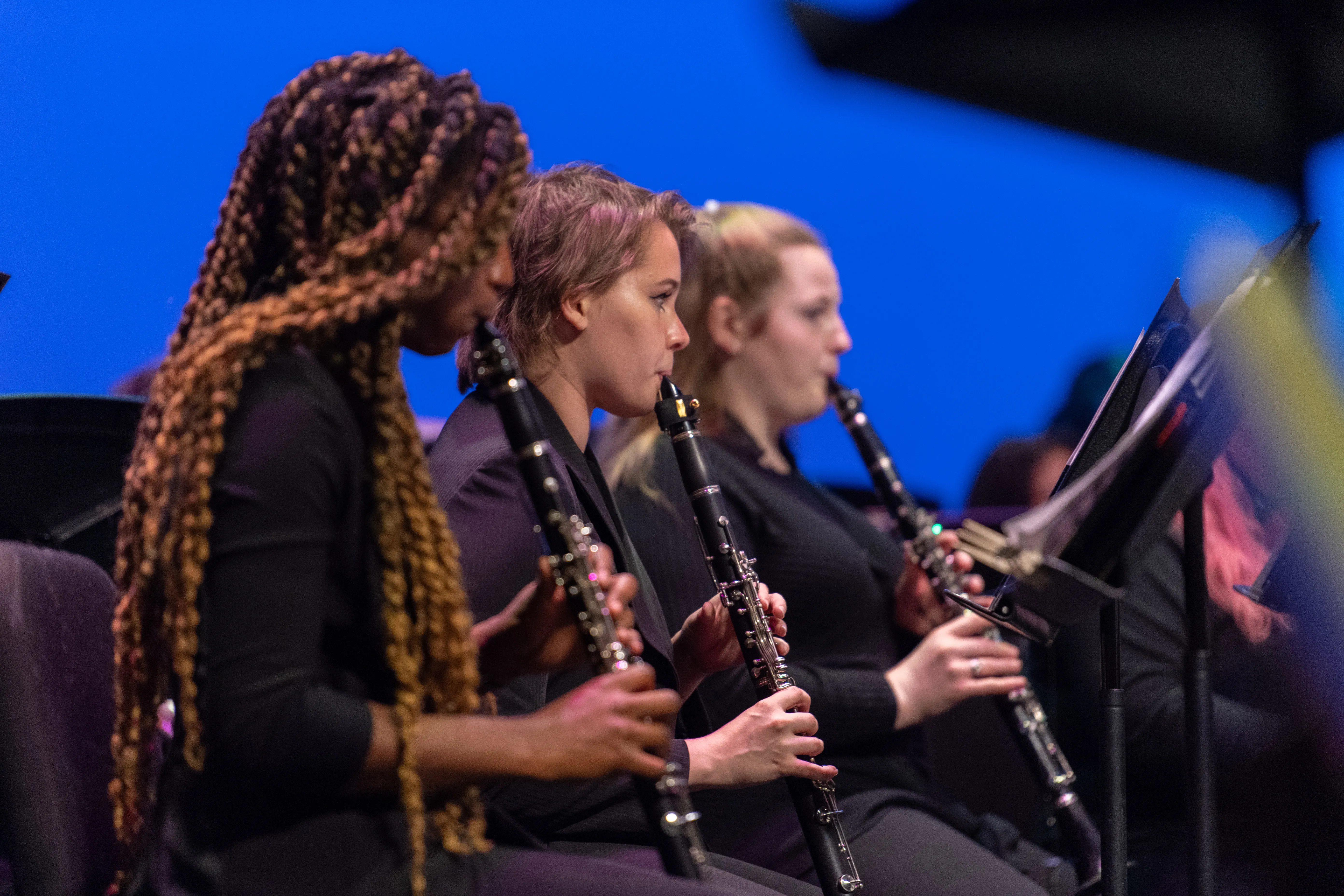 Three students playing clarinet