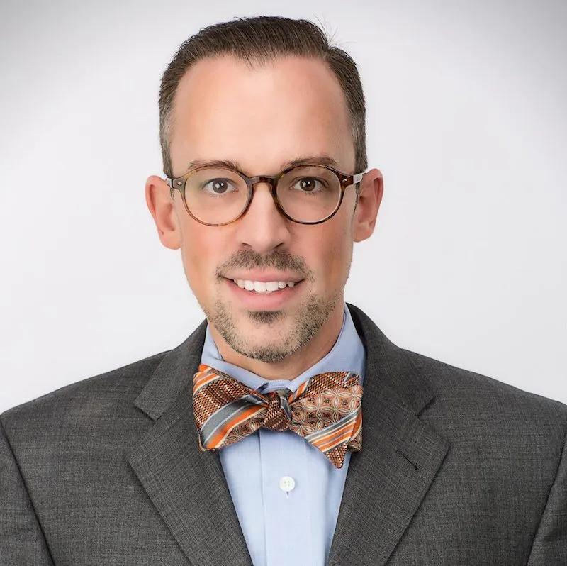 David in a suit and tie against a white background