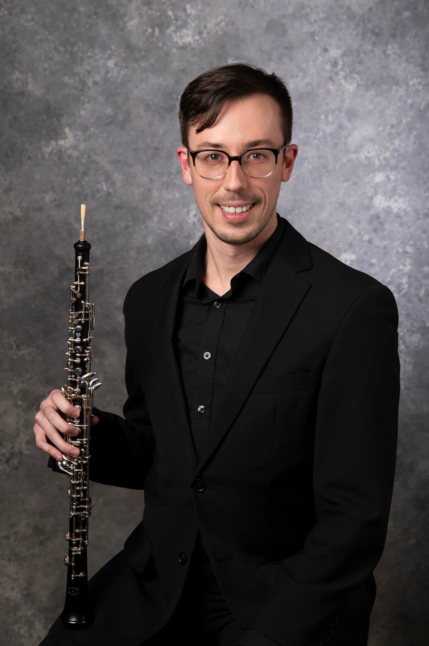 Nathan in all black clothing, holding an oboe
