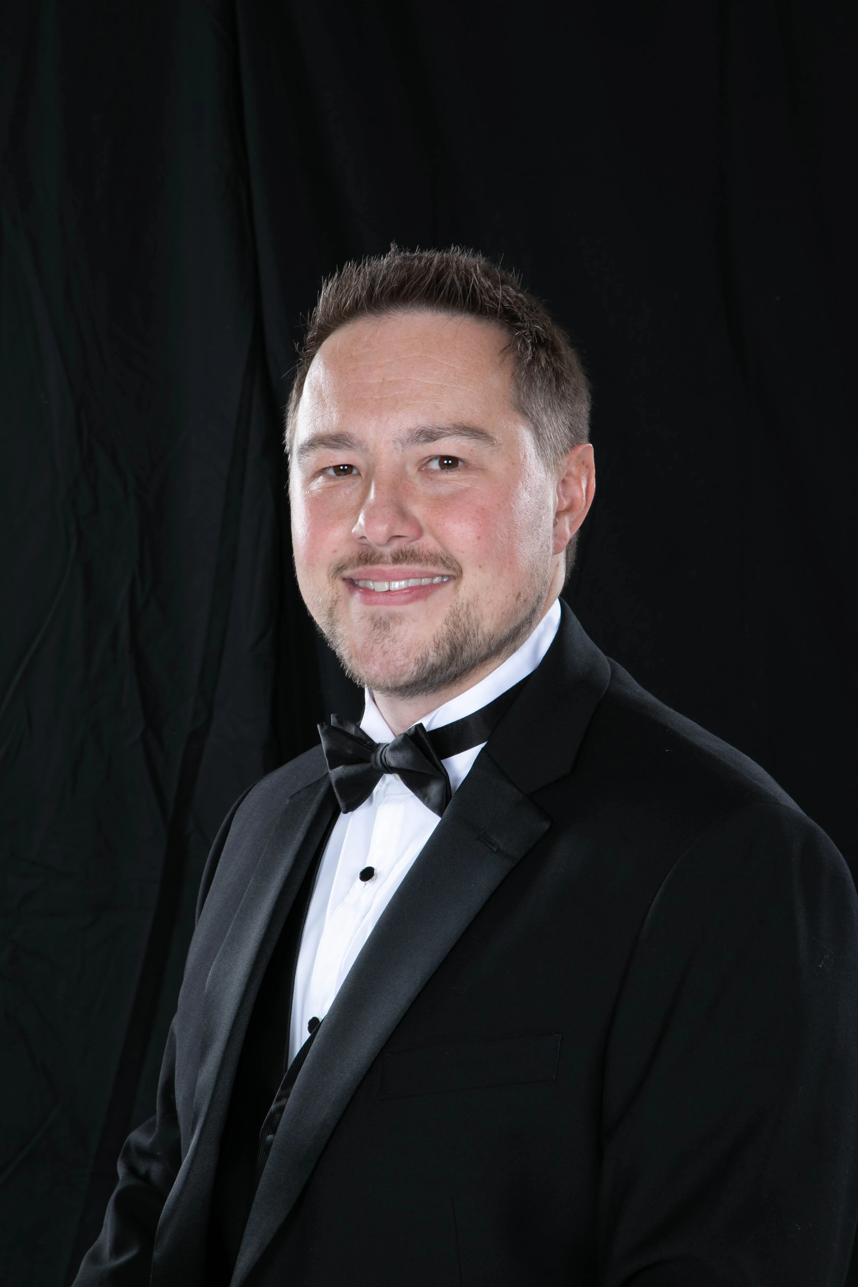 Adam in a black and white tuxedo