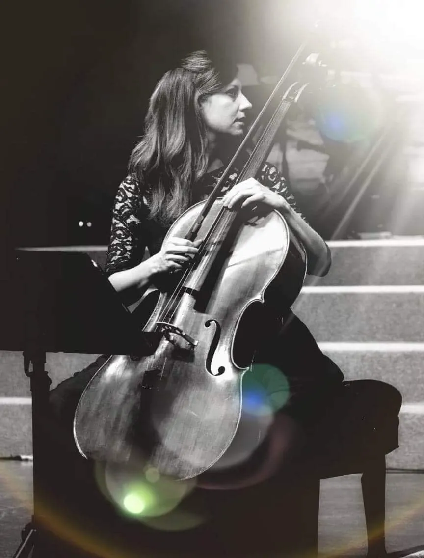 Kourtney on stage with a cello, black and white image