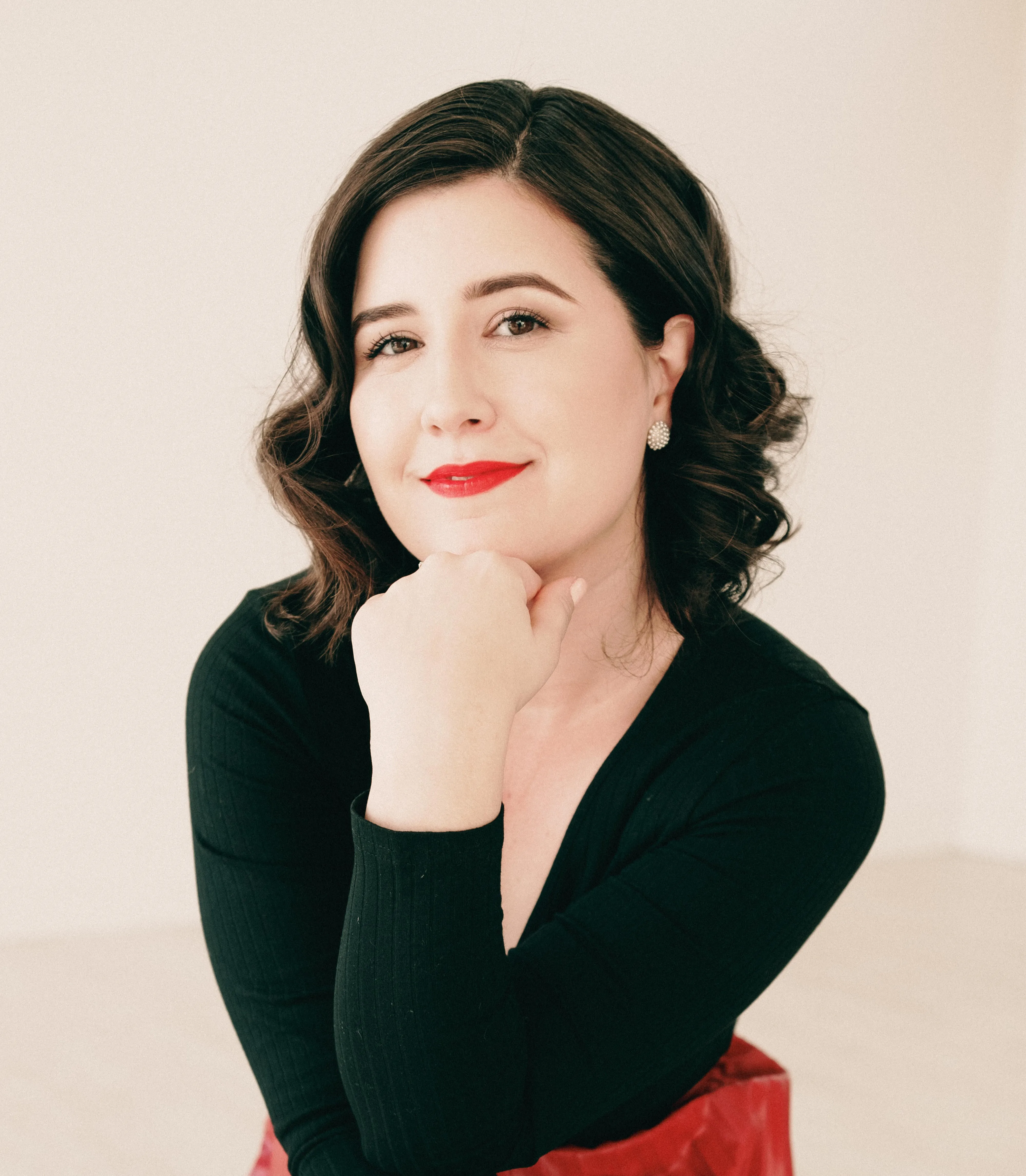 Ashley in a black dress against a white backdrop