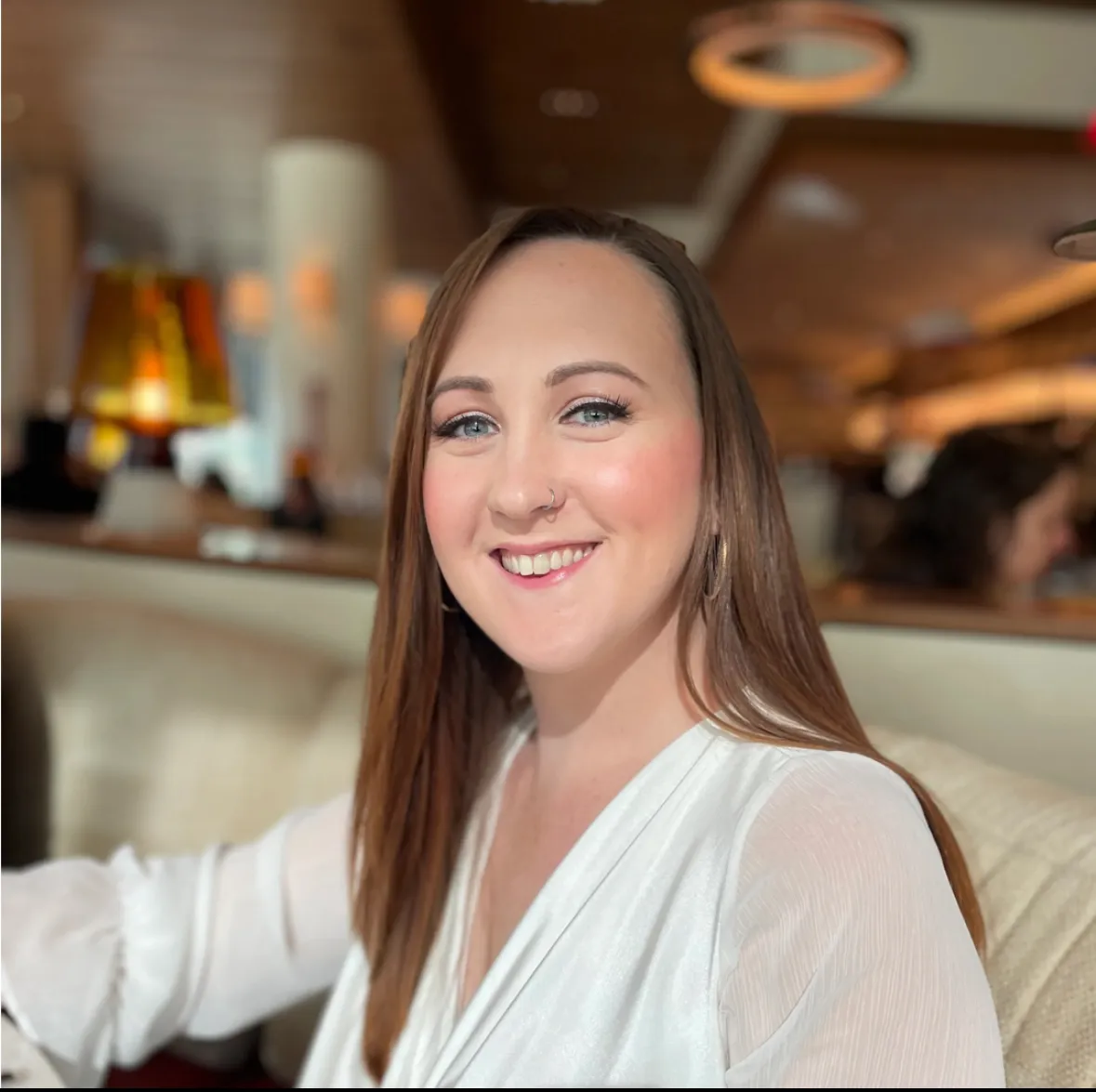 Cheri in a white top against the backdrop of a restaurant