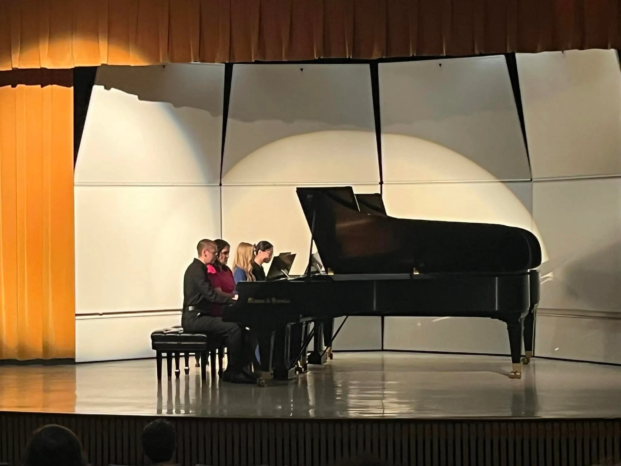 four pianists at two pianos on stage  
