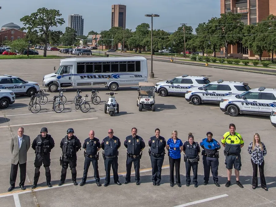 Members of police squad pose in front of police vehicles