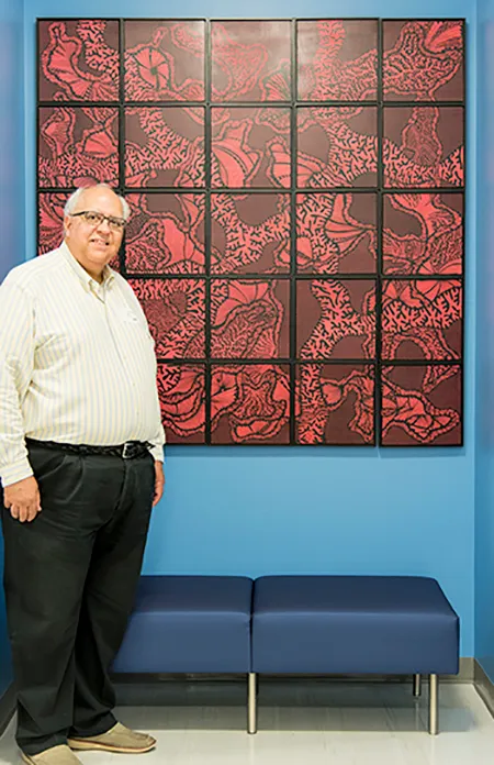 Dr. Michael Mistric in front of artwork he donated to the Harris County Institute for Forensic Sciences