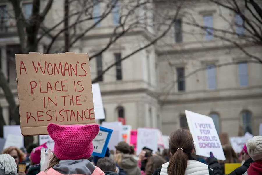A crowd at a women's march holding signs.