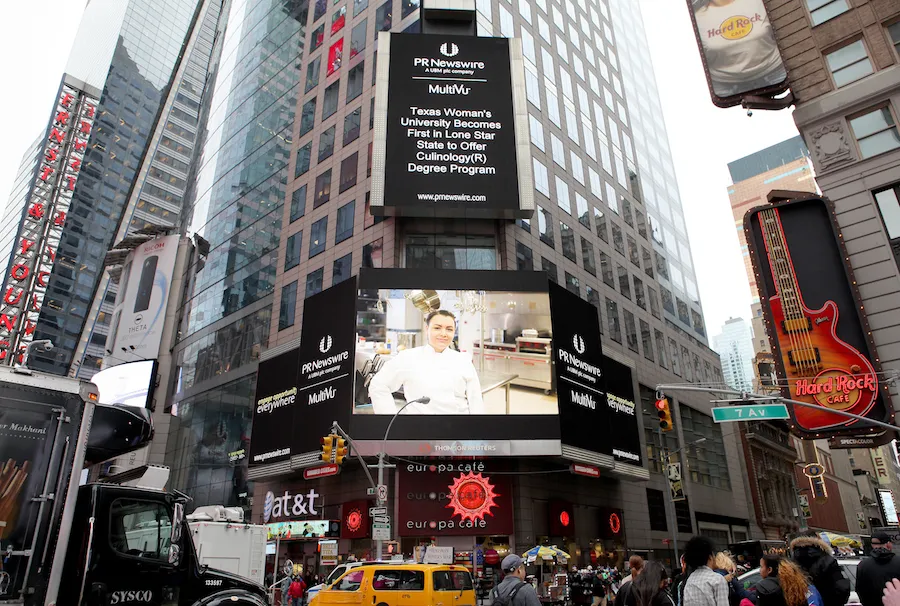 New York City Time Square buildings with large sign featuring smiling chef 