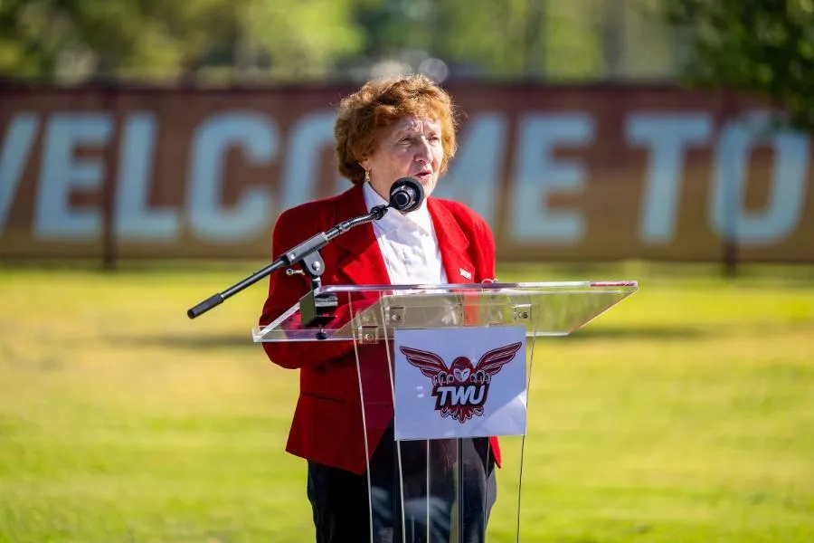 TWU alumna Dawn S. Cheney speaks at an outdoor podium