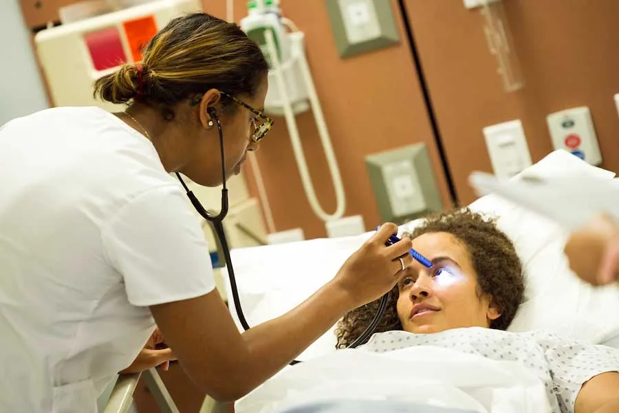 Nursing student checks patient