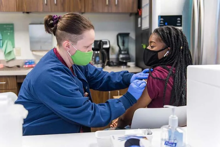 A TWU nursing student gives someone a flu shot