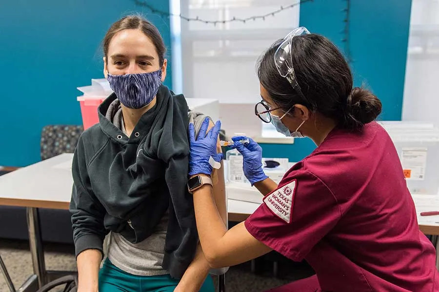 Nursing student gives flu shot.