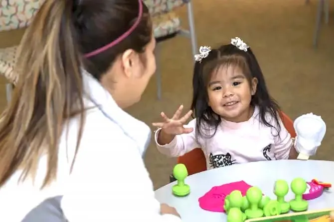 Therapy Together program student and child sit together at a child