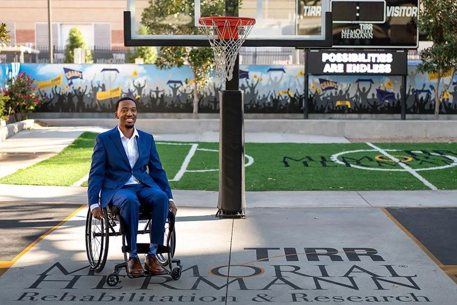 Daquan Minor, in a wheelchair, at an outdoor basketball court