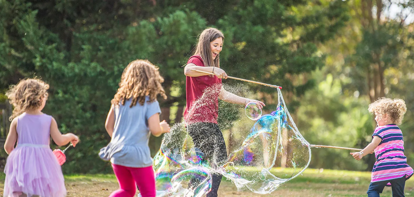 An occupational therapist uses bubbles to engage children on the autism spectrum in a natural environment