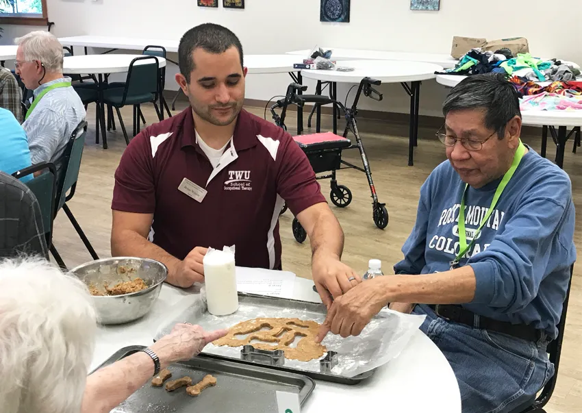 OT student works with adult patient on cookie cutter project 