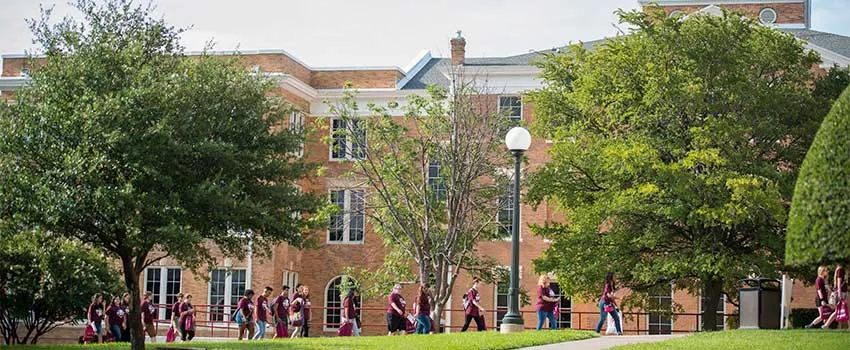 A group of students walk near Old Main on TWU's Denton campus. 