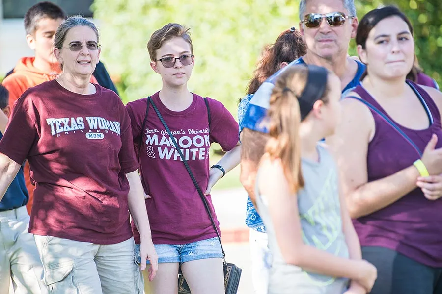 Family members walk with new students on campus