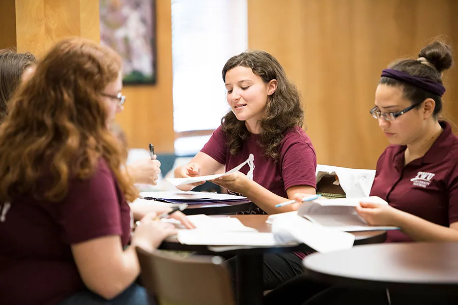 A group of TWU students study together at a shared table