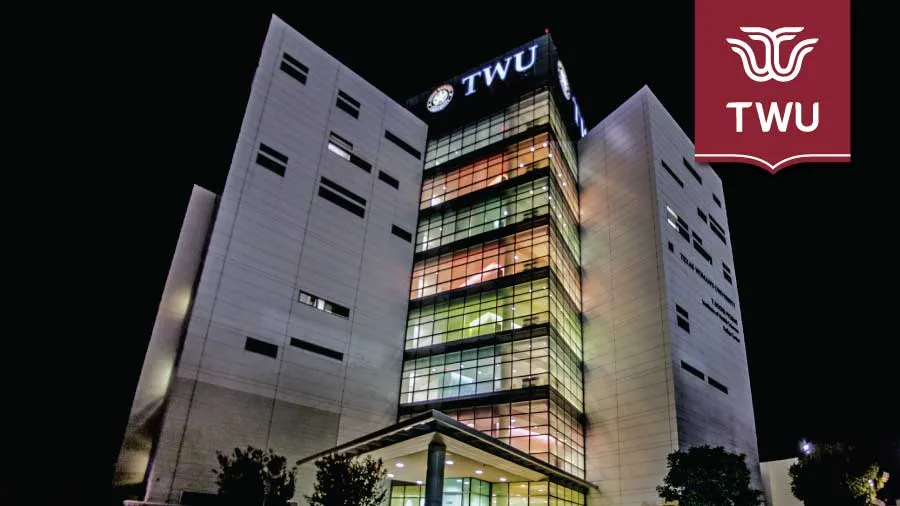 The Dallas campus lit up at night with a TWU logo banner in the top right.