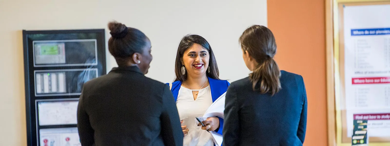 Three ̽��¥ students in business dress chat together