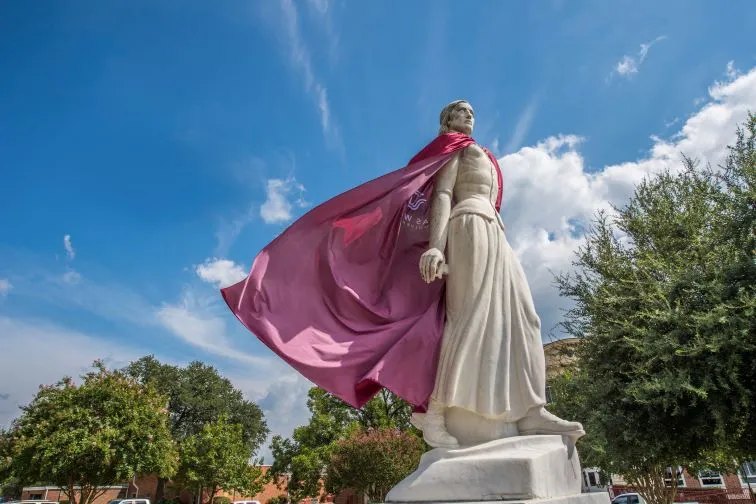 The TWU Pioneer statue, Minerva, wearing a burgundy cape.