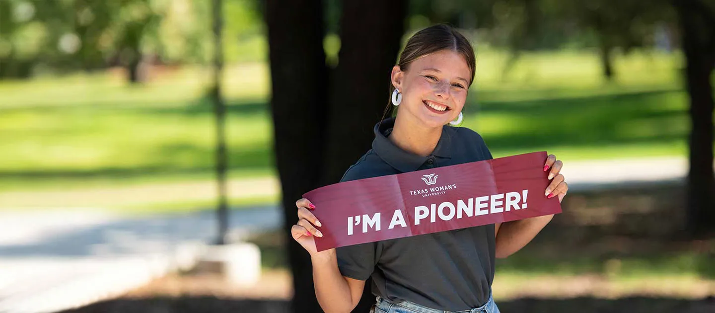 A TWU student holds a banner that says 