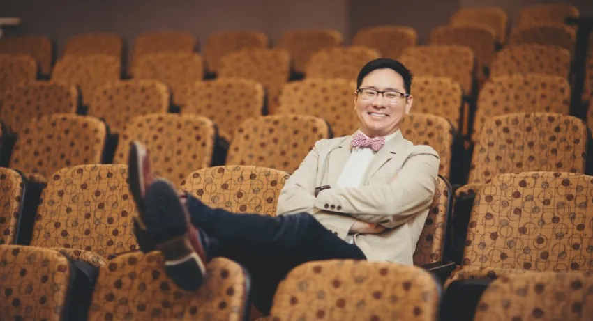 Dr. Sam Kim in a theatre seat  
