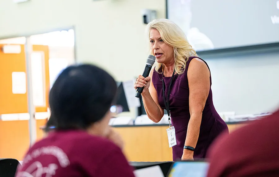 A TWU faculty member speaks to other faculty using a microphone