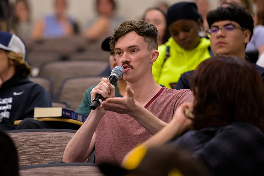 A TWU student asks questions during an audience Q&A portion of a presentation