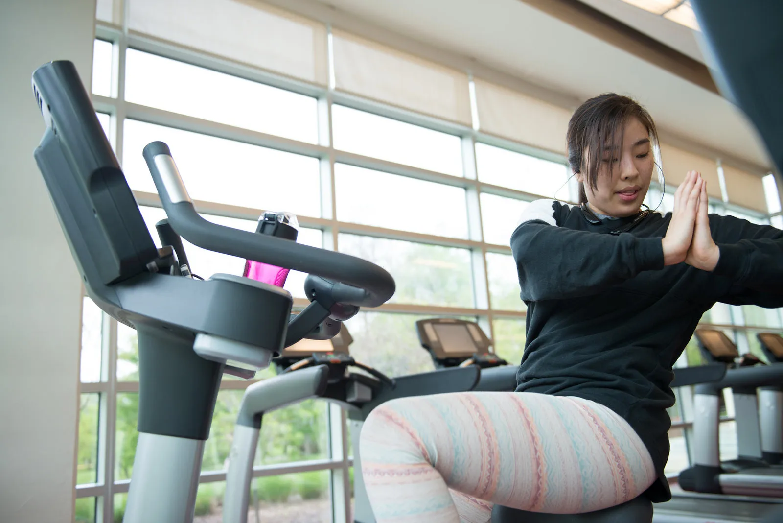 Woman at a stationary bike stretching. 