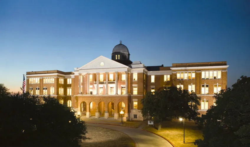 The outside of Old Main Building at Texas Woman's University at dusk. 