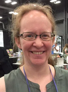 A woman smiling at a convention. 