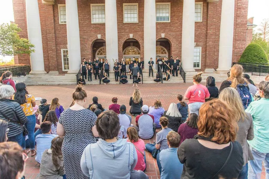 Singers and musicians perform on the TWU library steps in front of a crowd