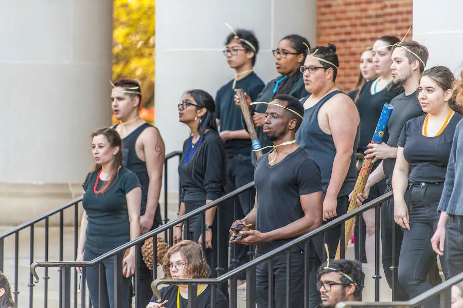 Singers and musicians perform on the TWU library steps in front of a crowd